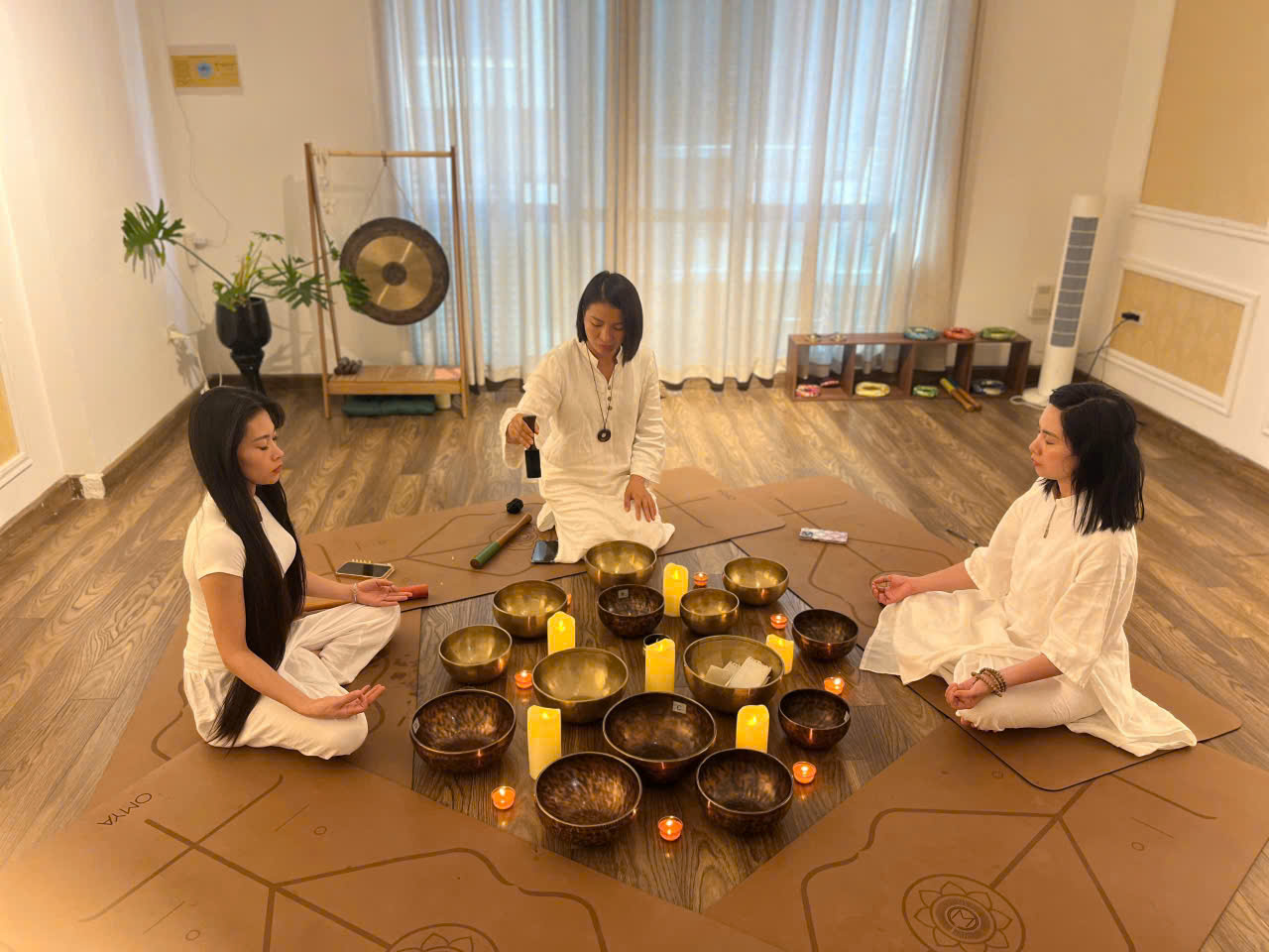 Không gian yoga nhỏ với chuông ngân và ánh đèn vàng ấm áp tại Metta Singing Bowl